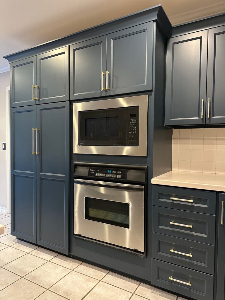 Dark blue kitchen cabinets refinished with modern hardware