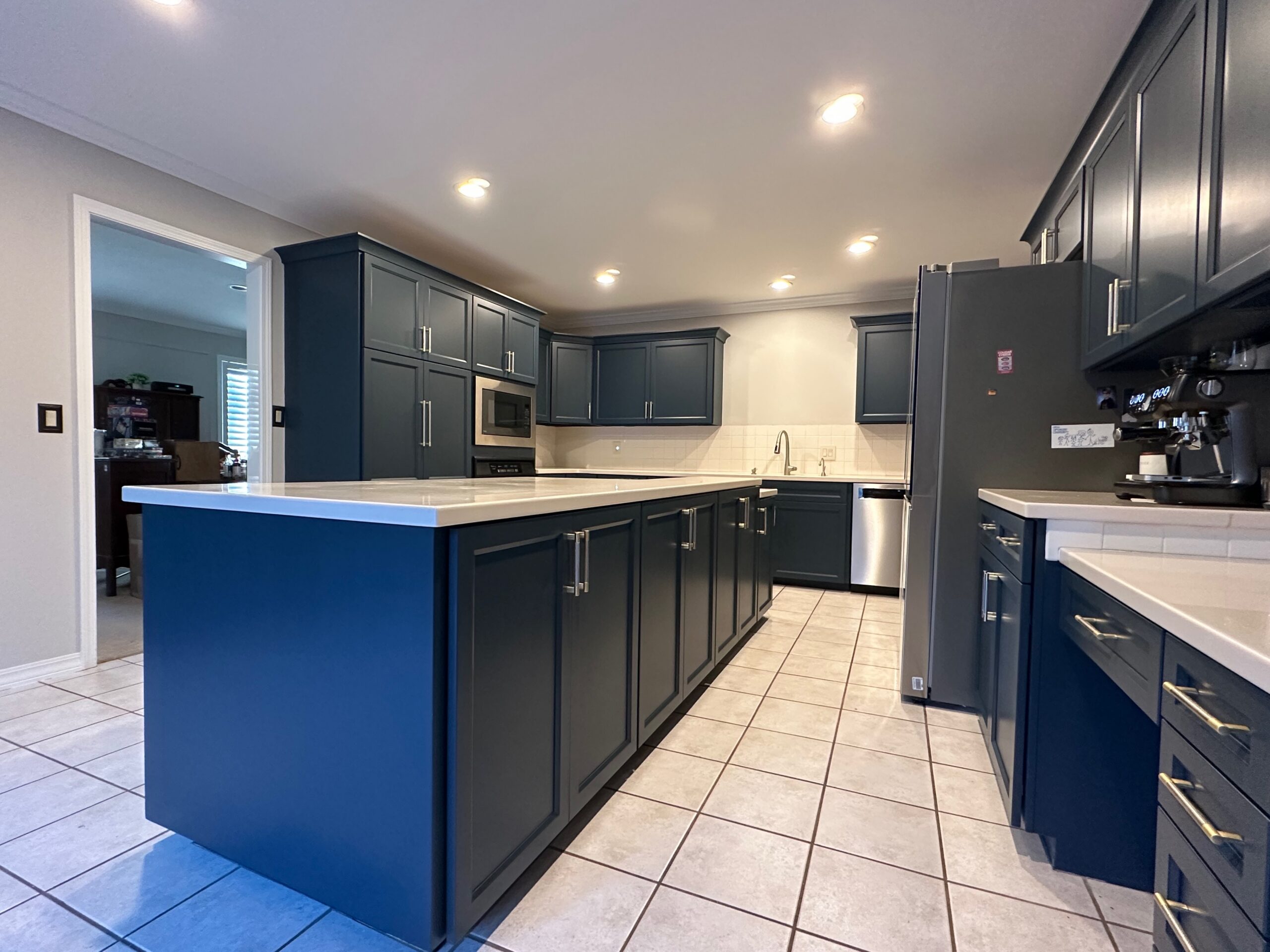 Finished kitchen with professionally painted blue cabinets after refinishing in Tulsa home