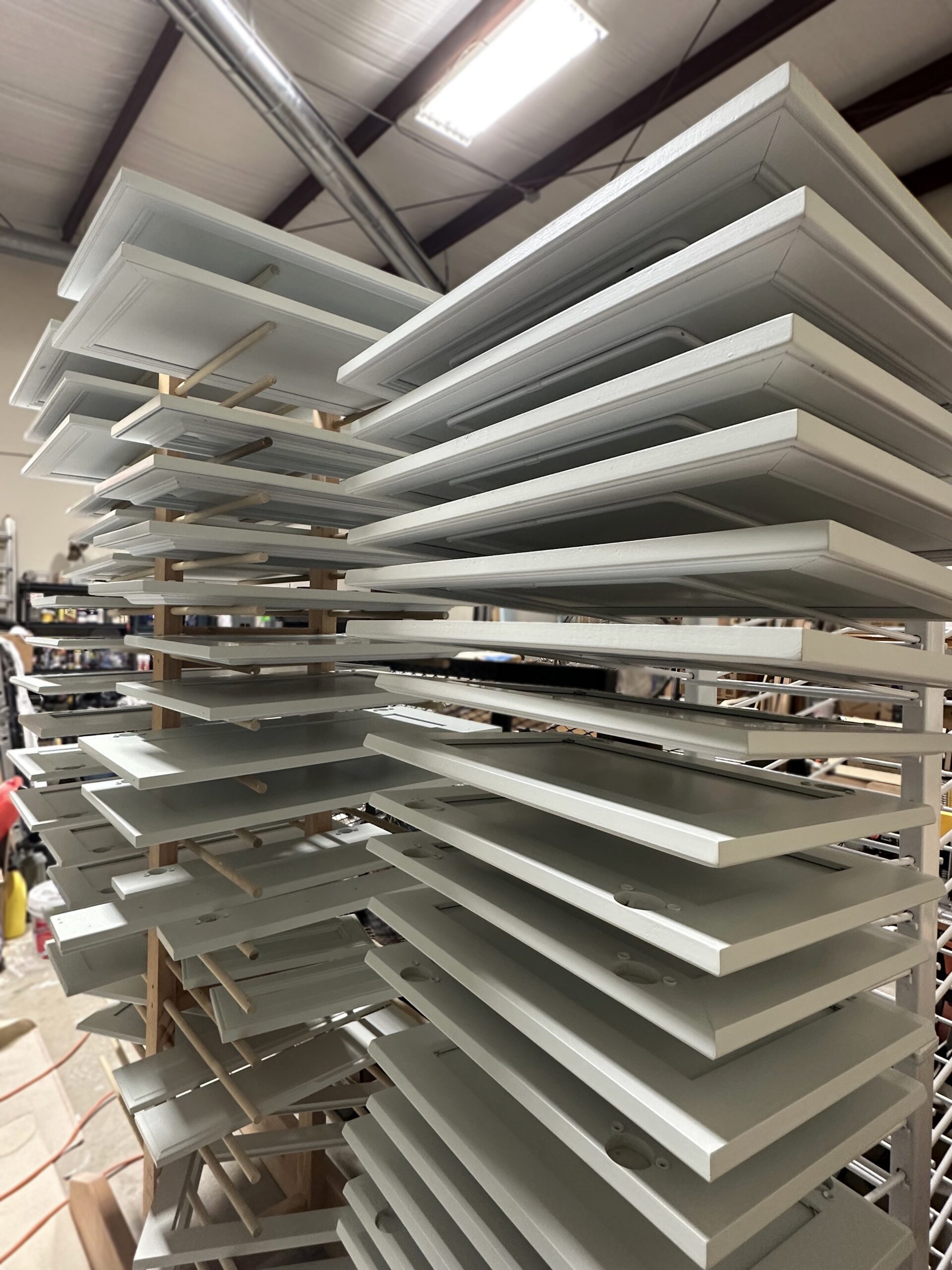 Cabinet doors drying on racks after professional spray painting and refinishing